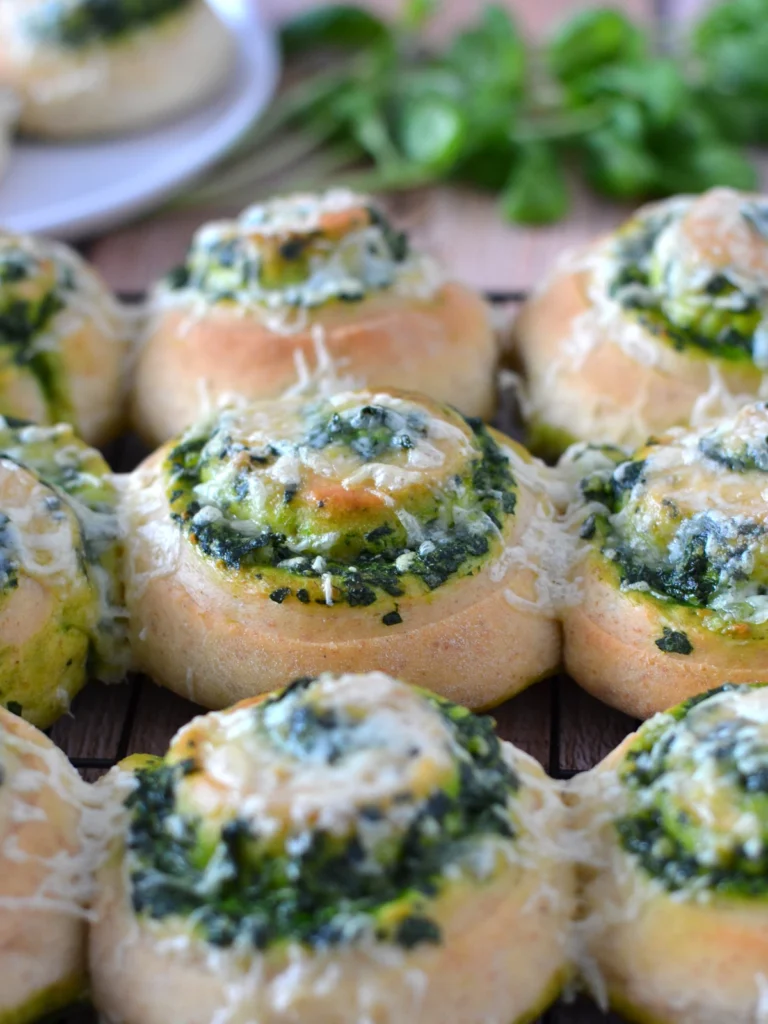 Vue de 9 brioches salées aux épinards et feta basilic garnie de fromage sur une grille