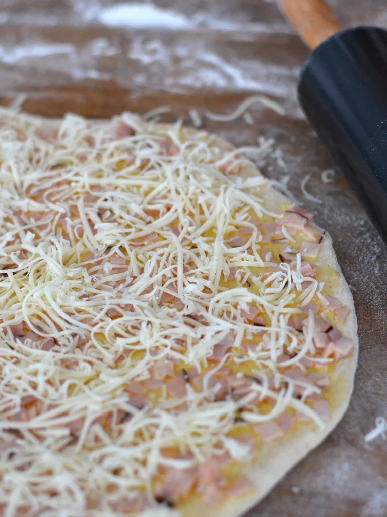 Pâte à brioches avant cuisson garnie de jambon et de fromage. 