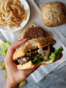 Burger végétarien vu de haut dans une main avec une bouchée prise