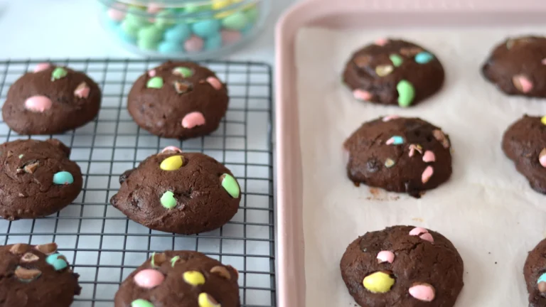 Biscuits moelleux doubles chocolats avec mini eggs répartis sur une grille et plaque de cuisson