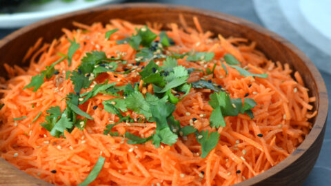 Salade de carottes et sésame Salade de carottes râpées garnie de sésame et de coriandre fraiche dans un bol de bois
