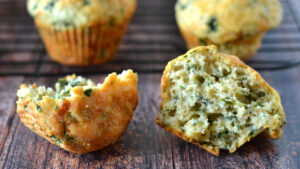 Un muffin au fromage et épinards déchiré en deux, montrant la texture moelleuse à l'intérieur.