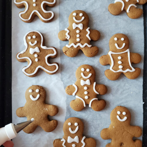 Biscuits au pain d'épices en forme de bonhommes, décorés de glace blanche.